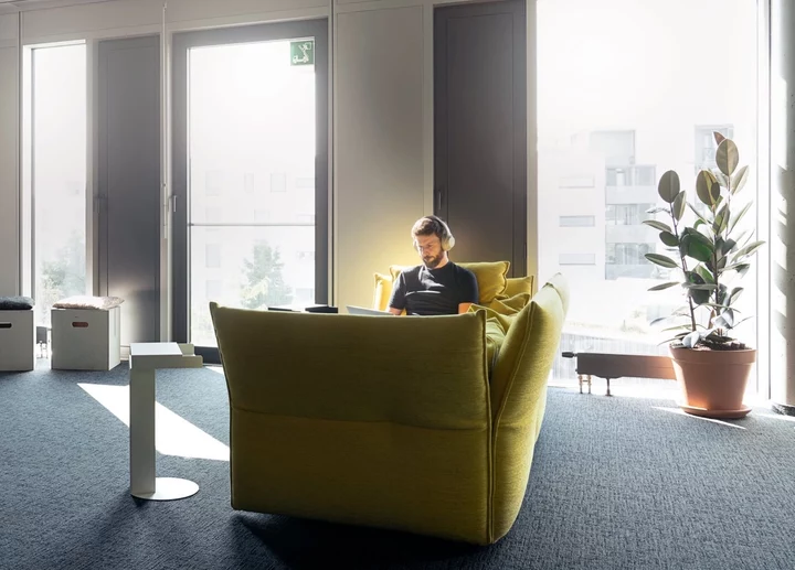 a man sitting in a good couch using his laptop